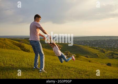 Padre e figlia spensierati che si divertono in collina Foto Stock