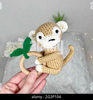 Giocattolo animale a crochet fatto a mano - giocattolo farcito Amigurumi - Scimmia a crochet Teetere di legno per bambini Foto Stock