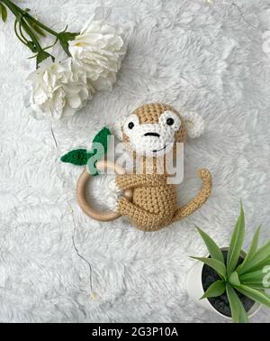 Giocattolo animale a crochet fatto a mano - giocattolo farcito Amigurumi - Scimmia a crochet Teetere di legno per bambini Foto Stock