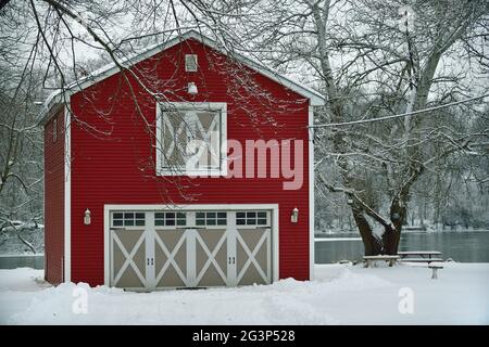 South Elgin, Illinois, Stati Uniti. Un granaio rosso convertito in un garage si distingue negli effetti di una tempesta di neve del Midwest nel nord-est dell'Illinois. Foto Stock