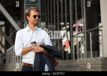 Successo e CEO di magra beve caffè sulla strada durante la pausa Foto Stock