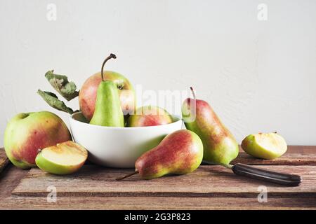 Mele e pere biologiche mature su tavola di legno, ancora vita. Foto Stock