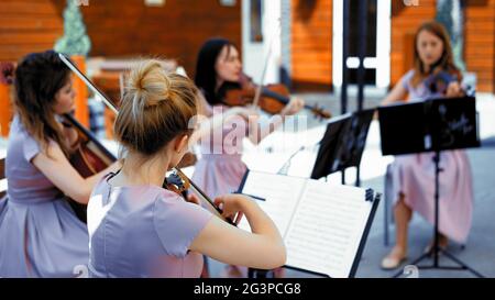 String Band di musicisti Girls suonano sulla terrazza estiva Foto Stock