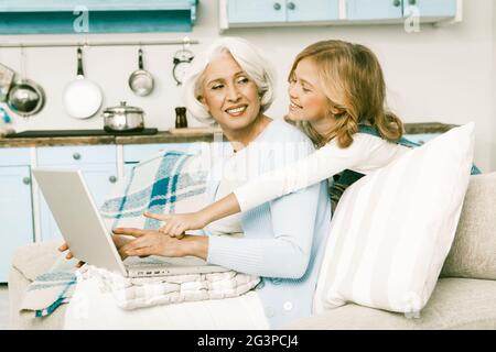 Nonna e bambina che fanno acquisti online utilizzando un computer portatile Foto Stock