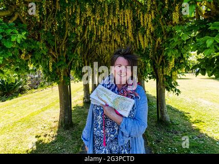 Haddington, East Lothian, Scozia, Regno Unito, 17 giugno 2021. Laburnum Arch allée in fiore: Lynn Fraser, artista e disegnatore locale noto come Fantoosh Art, traccia il bellissimo arco alberato che si trova nella Pleasance di Santa Maria, un patrimonio giardino murato Foto Stock