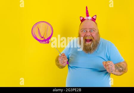 Fat uomo felice con fascia gioco con rete mare Foto Stock