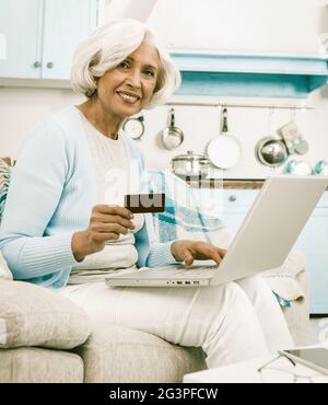 Nonna Utilizza Una Carta Di Credito Durante Lo Shopping Online Foto Stock