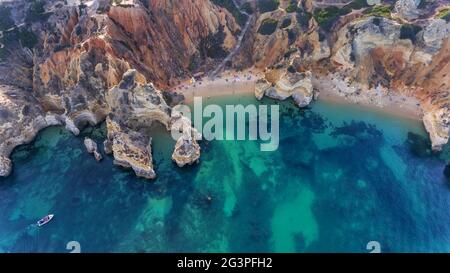 Spiaggia di Camilo a Lagos, Algarve - Portogallo. Scogliere portoghesi della costa dorata meridionale. Turisti in spiaggia. Soleggiato giorno vista aerea. Foto Stock