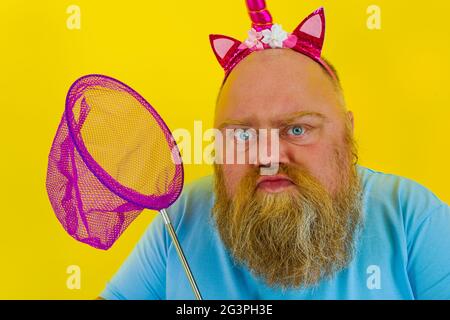 Uomo grasso pensieroso con fascia gioco con rete di mare Foto Stock