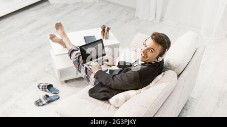 Uomo in cuffia che lavora da casa, vista dall'alto Foto Stock