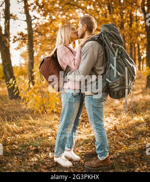 Coppia amorevole di viaggiatori Kisses nella foresta d'autunno Foto Stock