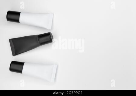 Tubi con cosmetici su fondo bianco. Foto Stock
