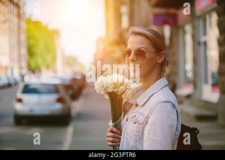 Bella e giovane donna con un bouquet di narcisi Foto Stock