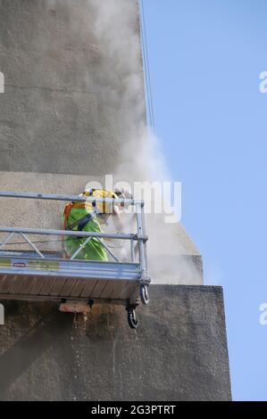 Lavoratori che sfregano la parete esterna dell'edificio Foto Stock