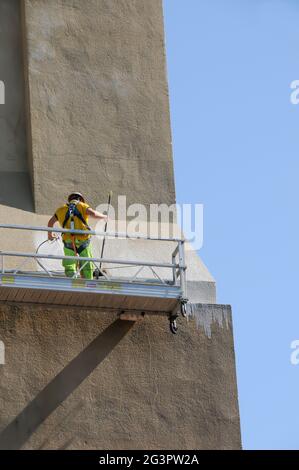 Lavoratori che sfregano la parete esterna dell'edificio Foto Stock