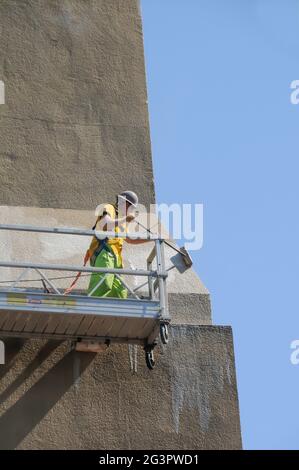 Lavoratori che sfregano la parete esterna dell'edificio Foto Stock