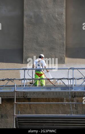 Lavoratori che sfregano la parete esterna dell'edificio Foto Stock