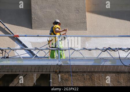 Lavoratori che sfregano la parete esterna dell'edificio Foto Stock