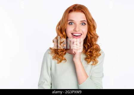 Ritratto fotografico di giovane ragazza dai capelli rossi che tocca il mento sorridendo pensieroso isolato su sfondo bianco Foto Stock