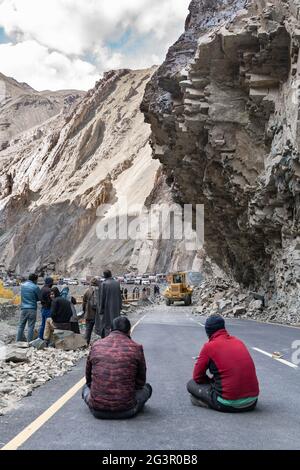 Il gruppo di conducenti di autocarri in attesa quando la strada sarà libera a causa della frana Foto Stock