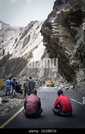 Il gruppo di conducenti di autocarri in attesa quando la strada sarà libera a causa della frana Foto Stock