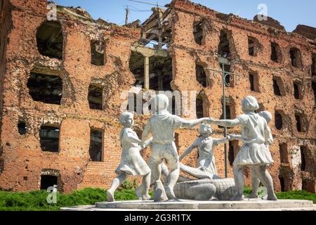 Volgograd/Russia-18.06.2016:la statua di con cerchio di bambini e coccodrillo e edificio distrutto Foto Stock