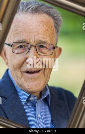 Il pensionato guarda attraverso una cornice Foto Stock