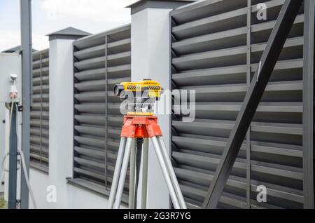 Rilevamento di apparecchiature di misurazione a livello di trasporto su treppiede in un edificio di costruzione Foto Stock