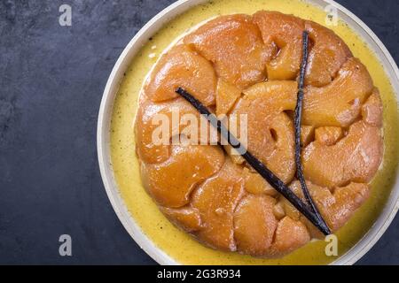 Tatin tradizionale francese con mele e vaniglia offerto come vista dall'alto su un piatto dal design moderno con spazio per la copia a sinistra Foto Stock