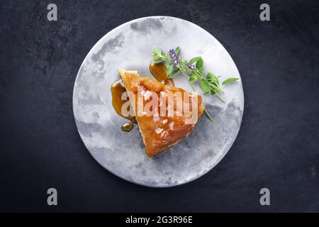 Tradizionale tatin francese con mele e vaniglia offerto come vista dall'alto su un design moderno piatto con sfondo rustico con Foto Stock