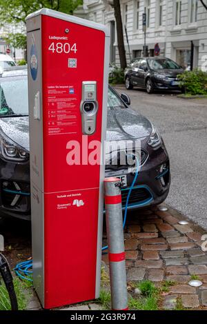 stazione di ricarica rossa per auto e in germania con un'auto in carica Foto Stock