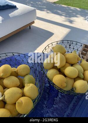 Colpo ad angolo alto di cestelli riempiti di limoni freschi su un tavolo Foto Stock