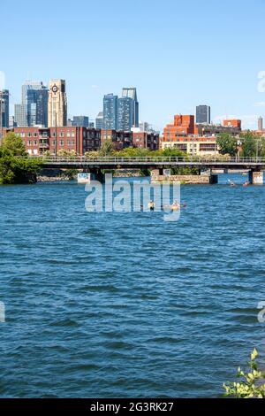 Vista del centro di Montreal e del mercato dell'acqua Atwater dal canale di Lachine con barche e kayak che galleggiano lungo Foto Stock