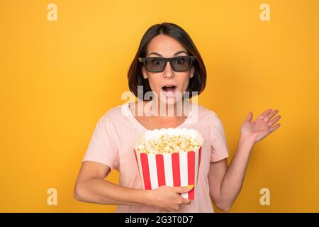 Giovane donna con un secchio di popcorn in occhiali stereo Foto Stock