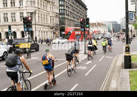 I ciclisti aspettano dietro il semaforo lungo la pista ciclabile vicino a Parliament Square, Londra, Regno Unito Foto Stock