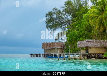 Bungalows su palafitte sulle spiagge di un'isola tropicale Foto Stock