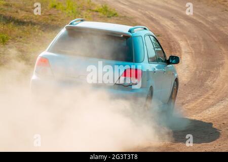 Vista posteriore di un'auto blu su una strada polverosa Foto Stock