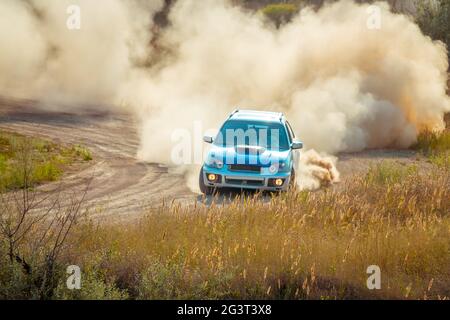 Auto sul Bend di una Sunny Dusty Road Foto Stock