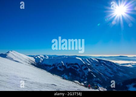 Sole invernale sulle vette delle montagne e sulle piste da sci Foto Stock
