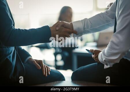 Handshaking di due colleghi di affari sulla base moderna dell'ufficio. Concetto aziendale. Primo piano Foto Stock