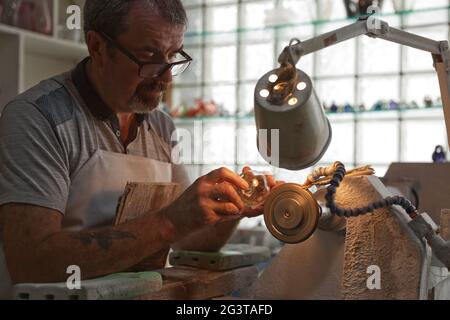 Un artigiano che lavora nel Dipartimento di scultura della fabbrica di cristallo di Waterford, nella città di Waterford, Repubblica d'Irlanda. Foto Stock