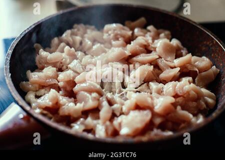 Pezzi di carne a fette vengono stufati in una padella. Arrostire la carne su una stufa elettrica. Foto Stock