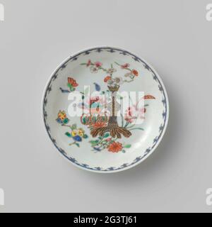 Piattino con Flowerbasket e vaso. Piatto di porcellana, dipinto sullo smalto in blu, rosso, rosa, verde, giallo, nero e oro. Sull'appartamento una pianta di loto con una foglia grande un vaso di fiori con ramo di prunus e un cesto floreale con peonia, accanto al cesto un ramo di frutta con limone dito; UN bordo di punta di spearhead sul bordo interno. Famiglia Rose. Foto Stock