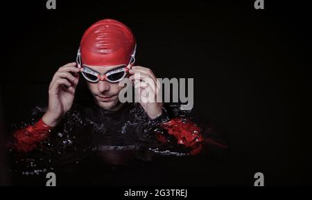 Un autentico nuotatore triatleta che fa una pausa durante un allenamento duro di notte Foto Stock