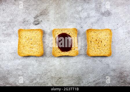 Fette di ruscelli allineate con marmellata su quella centrale Foto Stock