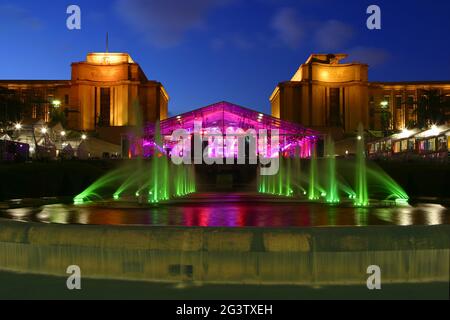 Vista del Palais Chaillot al TrocadÃ©ro, di fronte ad esso una fontana colorata illuminata Foto Stock