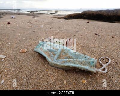 Rifiuti medici di Facemask chirurgici lavati in spiaggia Foto Stock