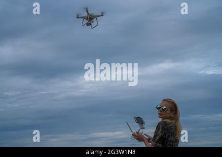 Donna felice che scatta foto con la fotocamera del drone Foto Stock