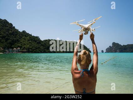 Drone nelle mani della donna sul mare e il cielo azzurro estivo Foto Stock