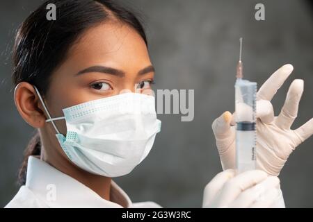 Primo piano di una giovane dottoressa con siringa Foto Stock